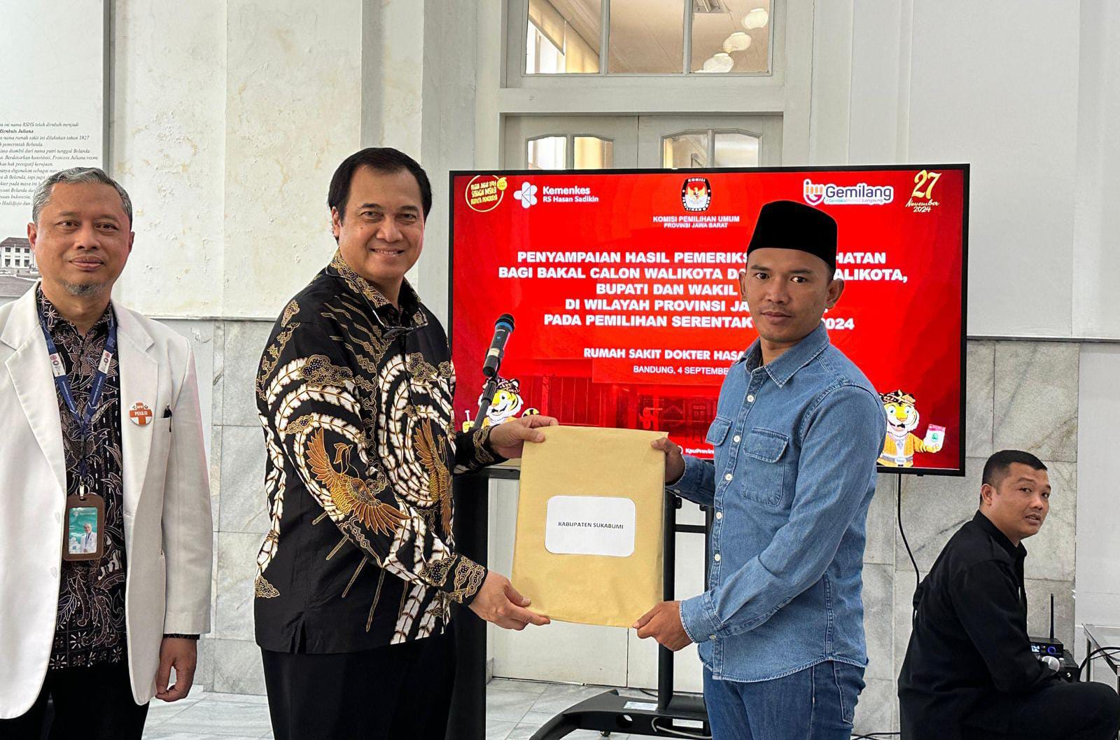 Ketua Divisi Teknis menerima hasil pemeriksaan kesehatan Paslon Iyos Somantri dan Asep Japar-Andreas dari RSHS Bandung - Foto : Istimewa