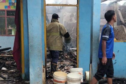 Petugas dan warga memadamkan sisa api di ruang kelas MTs Nurul Hasanah Curugkembar, Sukabumi. | Foto: Ist