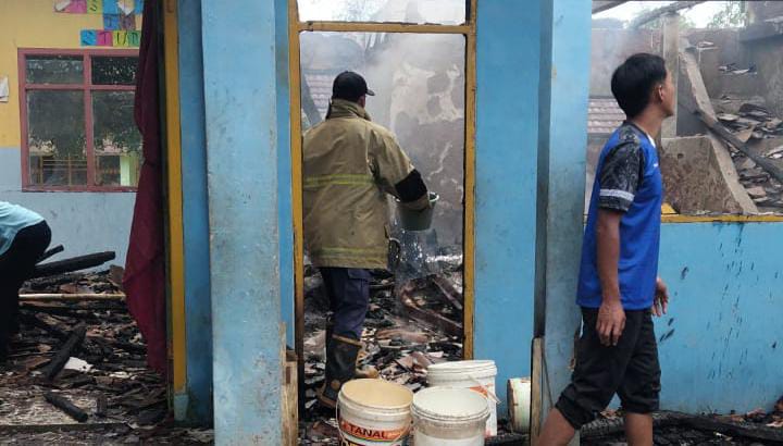 Petugas dan warga memadamkan sisa api di ruang kelas MTs Nurul Hasanah Curugkembar, Sukabumi. | Foto: Ist