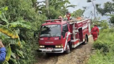 Momen armada Damkar Jampangkulon lewati jalan rusak menuju lokasi kebakaran rumah di Kampung Giri Asih, RT 19/03, Desa Waluran Mandiri. | Foto: Ist