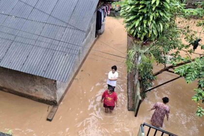 Warga melintas di permukiman yang terendam banjir setinggi paha orang dewasa di Kampung Panagan, Desa Pamuruyan, Kecamatan Cibadak, Kabupaten Sukabumi, Sabtu (7/2/2026). | Foto: Ans