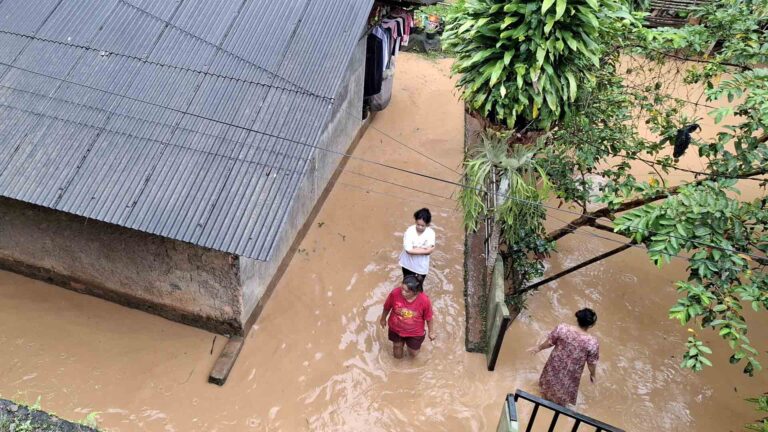 Warga melintas di permukiman yang terendam banjir setinggi paha orang dewasa di Kampung Panagan, Desa Pamuruyan, Kecamatan Cibadak, Kabupaten Sukabumi, Sabtu (7/2/2026). | Foto: Ans
